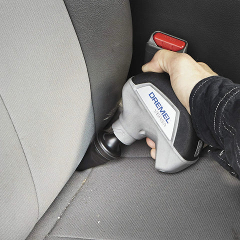 Cordless Power Scrubber Auto Detailing Kit With Four Cleaning Pads, Bristle Brush, shown cleaning car seat crevice.