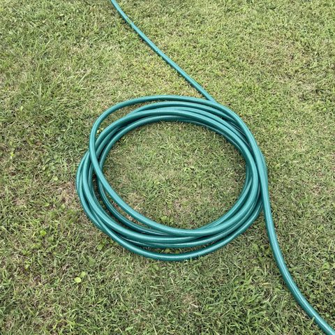 Heavy Duty Flexogen Three Quarters Inch By Fifty Foot Garden Hose With Eight Layer Construction And Five Hundred Psi Burst Strength coiled on grass