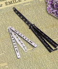 Butterfly Training Set Duo Dope Metal Flipping Tools with black and silver skeletonized handles on newspaper background
