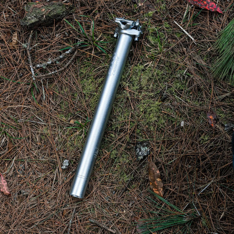 Crossfire Bike Seat Post 350mm Length, 27.2mm Diameter, AL6061 Aluminum, 3D Forged, Blast Silver Finish on forest floor
