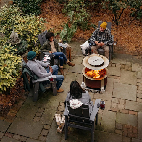 People enjoying a Smokeless Fire Pit For Outdoor Hangouts, 27.5 Inch X Series 24 Corten Steel Backyard Heater on patio