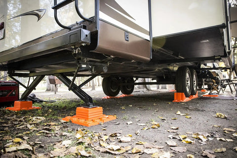 Stop N Chock 2 Pack For No Fuss Safe Parking And Easy Stabilization installed under RV, showing orange porous PLA chocks