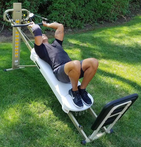 Person using EZ Curl Bar For Heavy Weight Training Fits Total Trainer Bowflex And Home Gym Cable Systems on outdoor lawn.