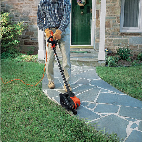 Person using 2 In 1 Electric Lawn Edger And Trencher With 12 Amp Corded Power, 7.5 Inch Cutting Width, along a sidewalk edge