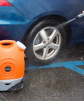 On The Go Portable Spray Washer With Built In Water Tank, orange unit with integrated wheels, cleaning car tire, not high pressure
