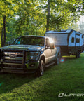 Truck towing RV with Through-Frame 2x2 RV Slide-Out Gear Pack Replacement For Quick Slide Restoration in a forest setting