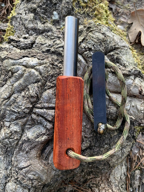 European Ferro Rod Fire Starter With Magnesium For Camping And Hiking on a tree trunk, showing hardwood handle and paracord
