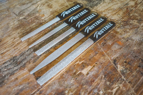 Heavy Hitter Flat Hand Rasp With Tungsten Carbide Coating And Ergonomic Soft Grip Handle For Workhorse Woodworking Shaping And Smooth Multidirectional Cutting 11 Inch Length displayed on a wooden surface.