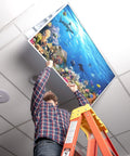 Man installing Easy Install Fluorescent Light Cover 2x4 Backlit Film Insert For Classroom Ceiling Lights, ocean design