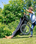 Person using Beefy Heavy Duty Utility Cart With 10 Cubic Feet Tub And 400 Pound Load Capacity With Flat Free Wheels outdoors