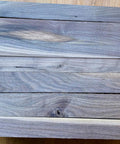 Scrap Walnut Box Of 3/4 Inch Thick Boards In A 17 By 14 By 5 Inch Crate, Leftover Walnut With Rough Edges And Knots, Perfect For DIY Woodworking, Crafts, Hobby Projects, And Reclaimed Lumber arranged on floor