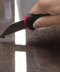 Allway Hardened Steel Plastic Sheet Cutter With Ergonomic Design For Easy Scribing Snapping Fiberglass And Vinyl Panels Home Shop Tool Heavy Duty Handle Comfort Grip Professional Grade Cutting Instrument cutting through plastic sheet on a wooden surface.