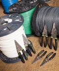 Pro Stainless Wire Stripper Cutter And Crimper Curve 6-14 AWG Solid And 8-14 AWG Stranded next to wire spools
