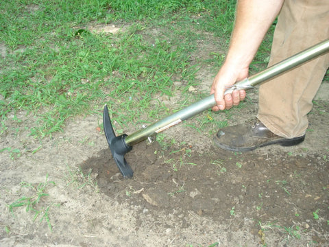 Person using Handle All Multi Purpose Tool Workhorse With Telescoping Handle And Full Size Shovel Sledge Hammer Axe And Pick Heads on dirt