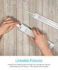 Hands connecting Premium Linkable Under Cabinet Light 18 Inch LED With 628 Lumens 3000K Warm White on wooden surface.