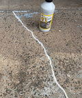 Bottle of 2X Concrete Crack Sealant Easy To Use No Mess Ready Mixed Filler For Cracks Up To Half Inch next to a filled crack on concrete