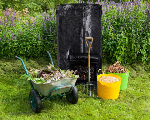 Outdoor Compost Bin For Garden 34 Gallon Reusable Yard Waste Bag alongside wheelbarrow and garden tools on grass background