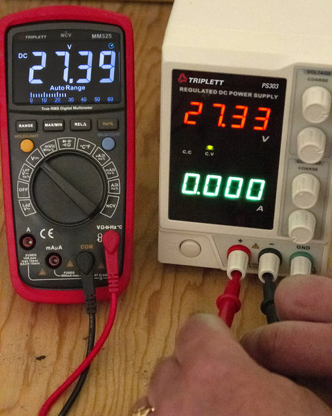 MM525 True RMS 6000 Count Digital Multimeter With NIST Calibration Certificate next to power supply showing measurements