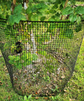 Hella Tough Black Plastic Garden Fence With Heavy Duty Hardware Mesh For Yard Barriers Tree Shields And Poultry Netting Measuring Forty Inches By Twenty Five Foot Long around a young tree.