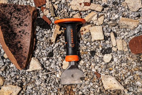 3 Inch Brick Chisel with Heavy Duty Hand Guard for Masonry Projects on gravel with broken bricks and stones