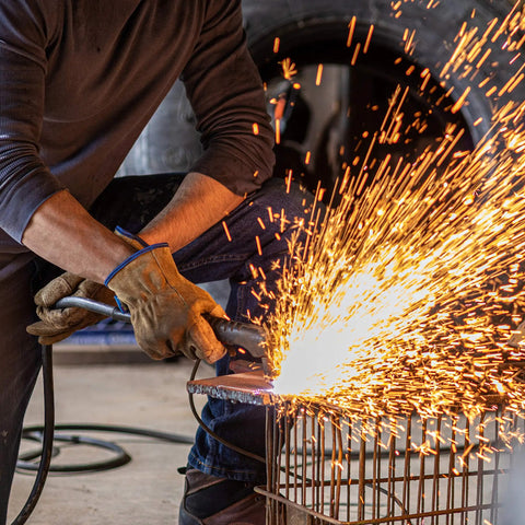 Man welding with HydraHyde Leather Work Gloves For Ranching, Fencing And Construction, Water Resistant Split Cowhide, Reinforced Palm
