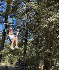 Backyard Zipline Seat For Trolley Use Heavy Duty Black Metal Swing Seat with woman using the zipline in a forest setting