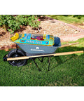 Five Cubic Foot Heavy Duty Garden Cart With 15 Inch Flat Free Tire loaded with soil bags on grass near a flower bed