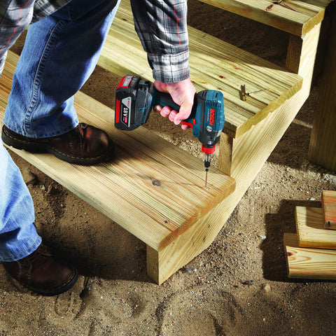 Person using 10-Pack 3 And A Half Inch Phillips No. 1 Impact Tough Screwdriving Bits for High Torque Applications on wooden stairs