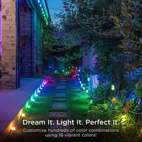Lit Color Changing LED Landscape Path Lights Kit illuminating a garden walkway with vibrant colors and bronze metal lights.
