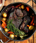 Hybrid Nonstick 5-Quart Dutch Oven With Stainless Steel Lid filled with braised beef, carrots, potatoes, and rosemary.