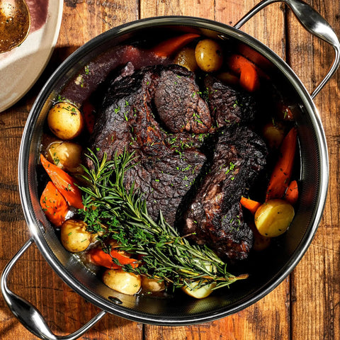 Hybrid Nonstick 5-Quart Dutch Oven With Stainless Steel Lid filled with braised beef, carrots, potatoes, and rosemary.