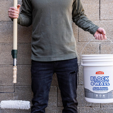 Person holding Block And Wall Liquid Rubber Waterproofer Pro Grade Multi Purpose Coating And Sealant For Concrete Walls And Foundations 1 Gallon White Made In USA Waterproof Basement Sealer bucket