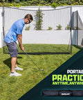 Man using Limited Edition Black Golf Practice Net with Large 10 Ft By 7 Ft Hitting Space Pro Grade Personal Driving Range outdoors.