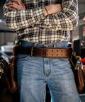 Man wearing genuine leather tool belt for men with pouches and boss grade heavy duty saddle design for framers and carpenters.