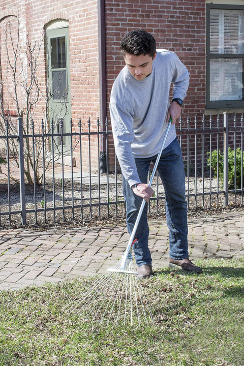 Man using Telescopic Folding Garden Rake With Adjustable Head And Beefy Heavy Duty Steel Tines Extendable From 37 To 68 Inches.