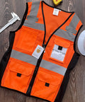 Womens Slim Fit Reflective Safety Vest With 11 Spacious Pockets Breathable Mesh High Vis Orange Work Gear Built Hella Comfy For Hectic Job Sites Flexible Waistband For Smooth Movement And Solid All Day Visibility on wooden surface with tools.