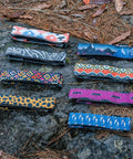 Assorted colorful Rockband Frame Carrying Strap for Inner Tubes and Bike Tools displayed on rocks, no backpack needed.
