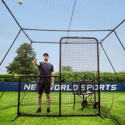 Man pitching ball inside Trapezoid Baseball Batting Cage Kit With Complete Cage, Connector Set, And Premium Net Package For 55Ft Practice Tunnel
