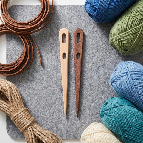 8-Piece Wooden Big Eye Knitting Needles With Double Eye Design And Smooth Rounded Tips For Wool And Nylon Crafts, Ideal For Scarves Macramé Tapestry And Crochet Projects For Yarn Lovers. Two wooden needles with yarn skeins.