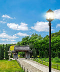 Kent One Light Outdoor Post Lantern With Slick Black Finish in garden, 20.25 inch height, illuminating pathway, clear sky