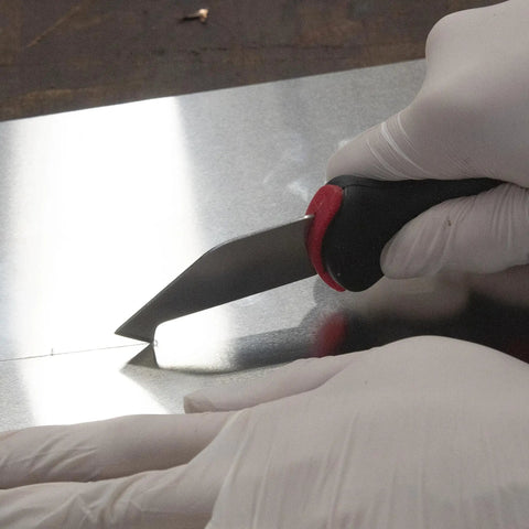 Close-up of Allway Hardened Steel Plastic Sheet Cutter With Ergonomic Design scoring a fiberglass sheet for precise cuts.