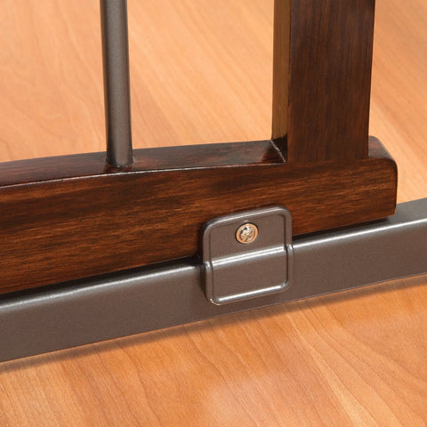 Close-up of Walk Through Baby And Pet Gate With Walnut Wood And Charcoal Metal Accents showing frame edge and lock detail.