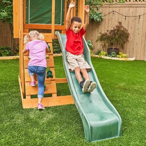 Children playing on a Weatherproof Wooden Swing Set For Backyard With UV And Mold Protection, slide and rock wall visible.