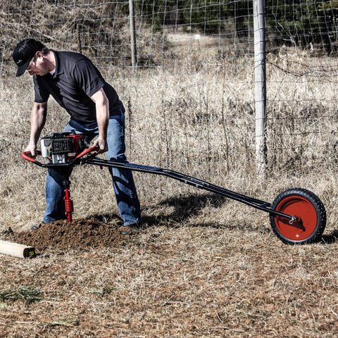 1-Man Earth Auger Powerhead With Sidekick Auger Torque Reducer For One-Man Operation in action, digging soil in a rural setting