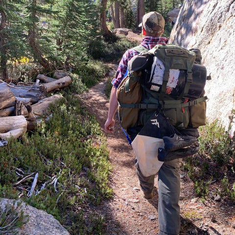 Person hiking with Water Filtration Bag For Bushcraft And Military Use, Second Edition With Taped Seams, Handmade In The UK attached.