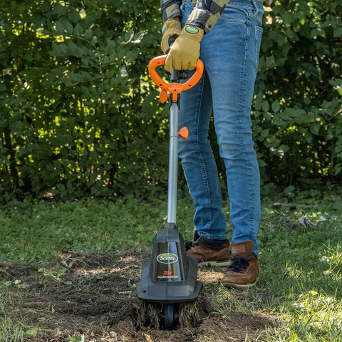 Person using 20V Cordless Garden Tiller Cultivator With 7.5 Inch Width, 6 Inch Depth, 4 Steel Tines in a garden
