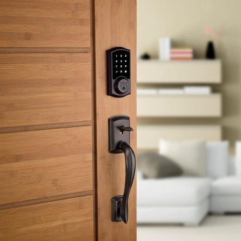 SmartCode 915 Touchscreen Electronic Deadbolt With Smart Key UL Listed Illuminated Keypad installed on wooden door in living room.