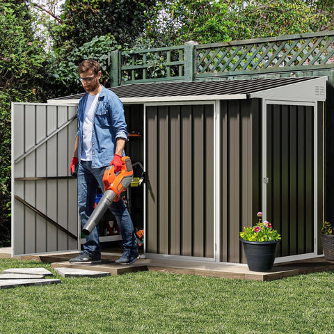 Man using a leaf blower outside a 7x4 Foot Outdoor Weatherproof Storage Shed With Lockable Dual Doors, Secure Metal Bike and Tool Storage.