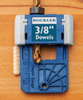 Close-up of 3/8 Inch Doweling Jig Kit With Drill Bit and Stop Collar on wood surface, featuring depth gauge markings.