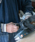 Person using Go-To Corded Belt Sander With Dust Bag, 7 Amp Motor, 3 Inch By 21 Inch Belt, Lightweight Six Pound Body on wood surface